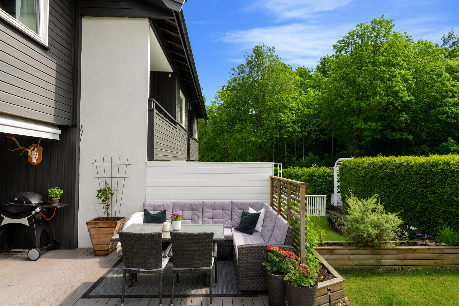 Terrassen er oppført med impregnerte terrassebord og har god plass til både spisegruppe og sittemøbler. En stor markise gir mulighet for skygge på varme dager. Bildet er AI-redigert. Galleribilde