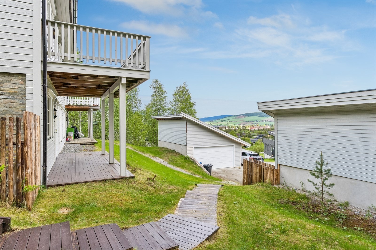 Boligen har flere uteplasser, inkludert en overbygget terrasse for utleiedelen og en veranda for hoveddelen i etasjen over. Galleribilde