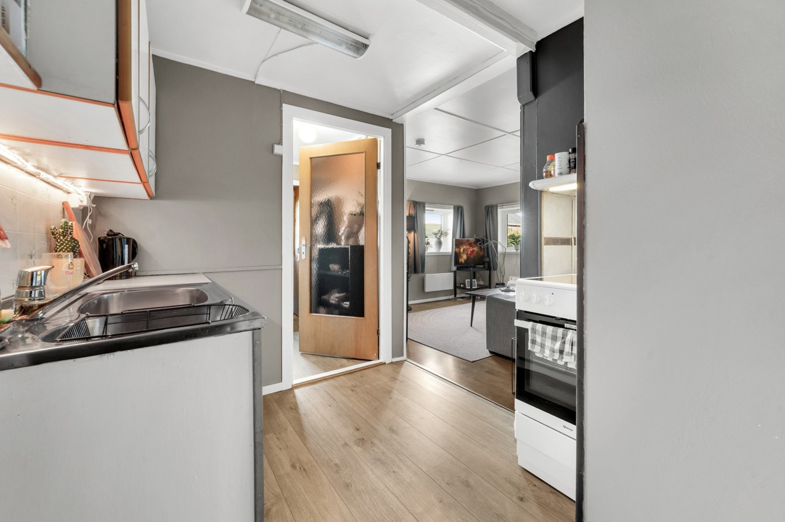 Fra kjøkkenet er det åpen tilgang til et stuerom. Foto: H5 properties Galleribilde
