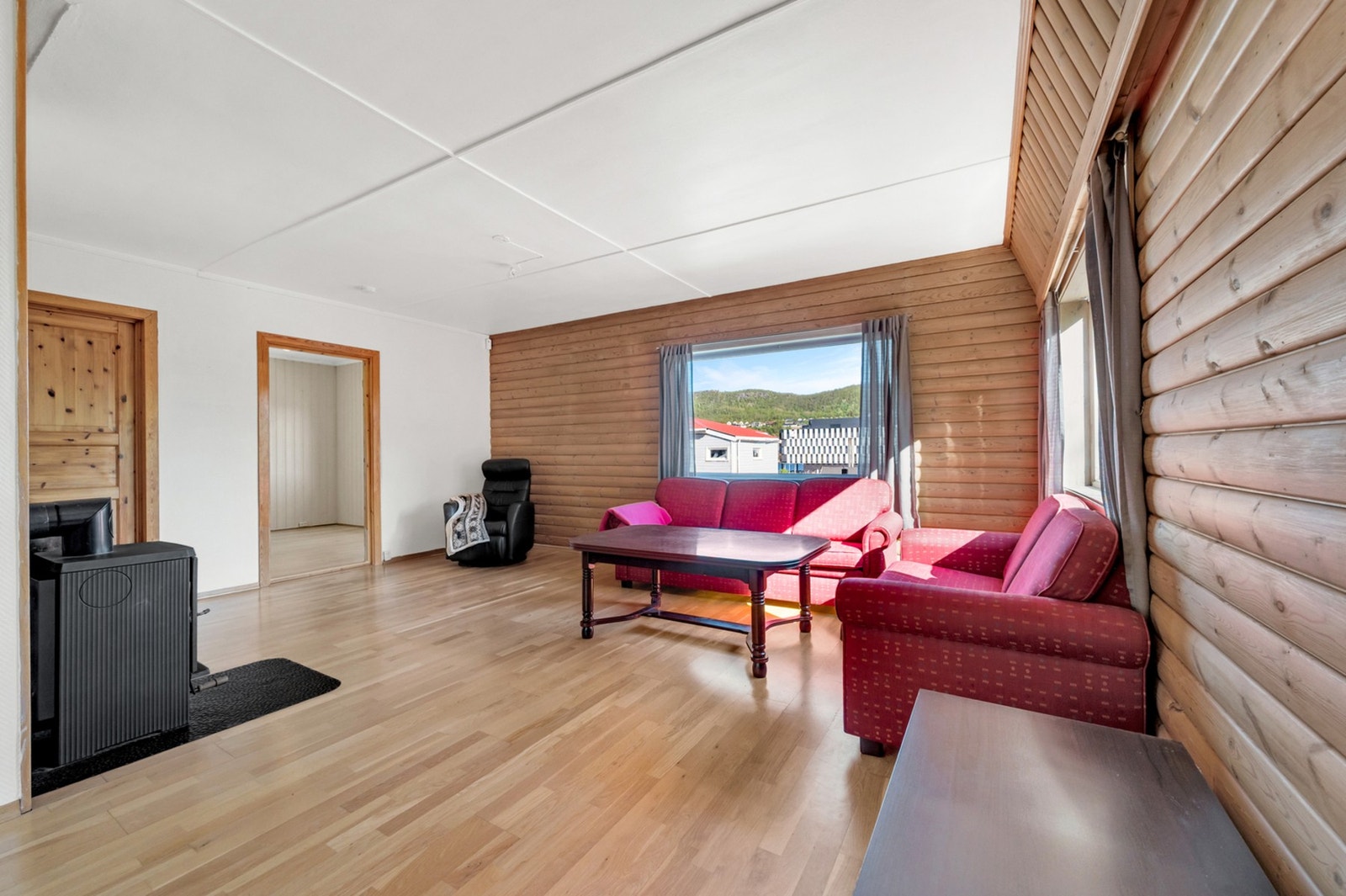 Stuen har vegger med en kombinasjon av trepanel og malte flater. Foto: H5 properties Galleribilde