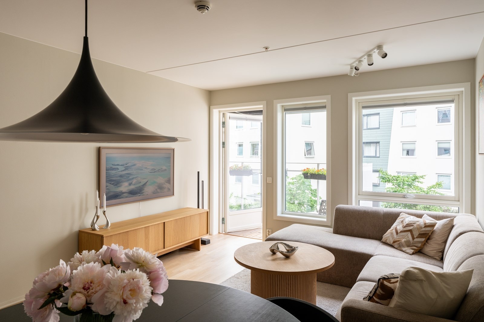 Store vinduer fra gulv til tak slipper inn rikelig med dagslys og bidrar til en lys og luftig atmosfære. Galleribilde