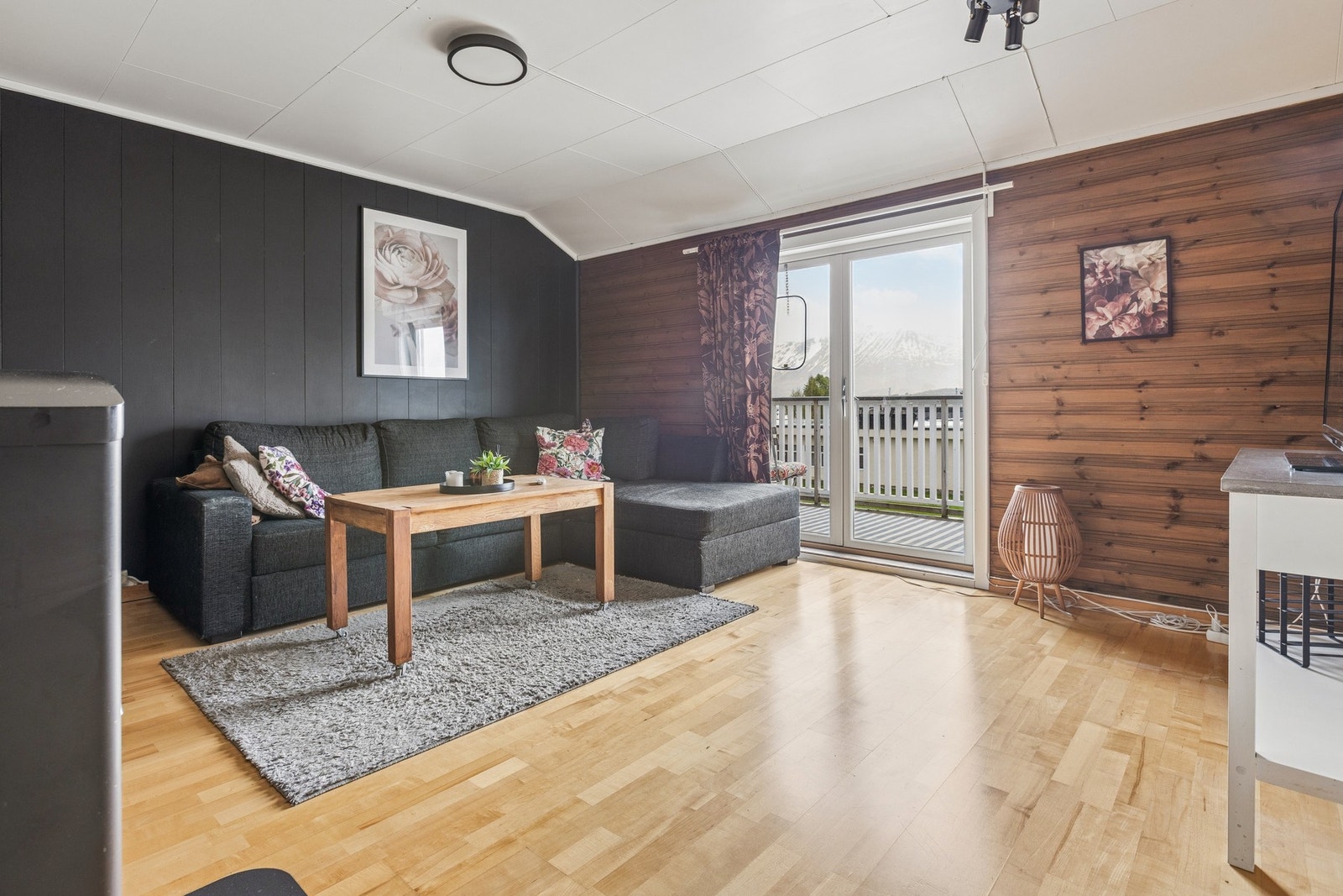Stue i 2. etasje med panel på veggene og utgang til balkong. Galleribilde
