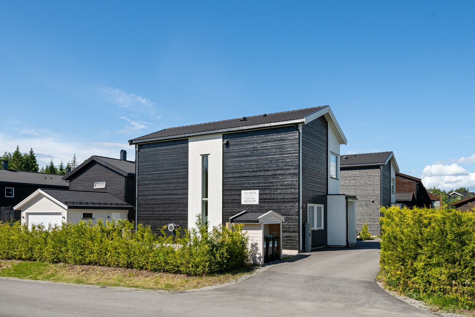 Asfaltert gårdsplass og pent opparbeidet uteområde. Galleribilde