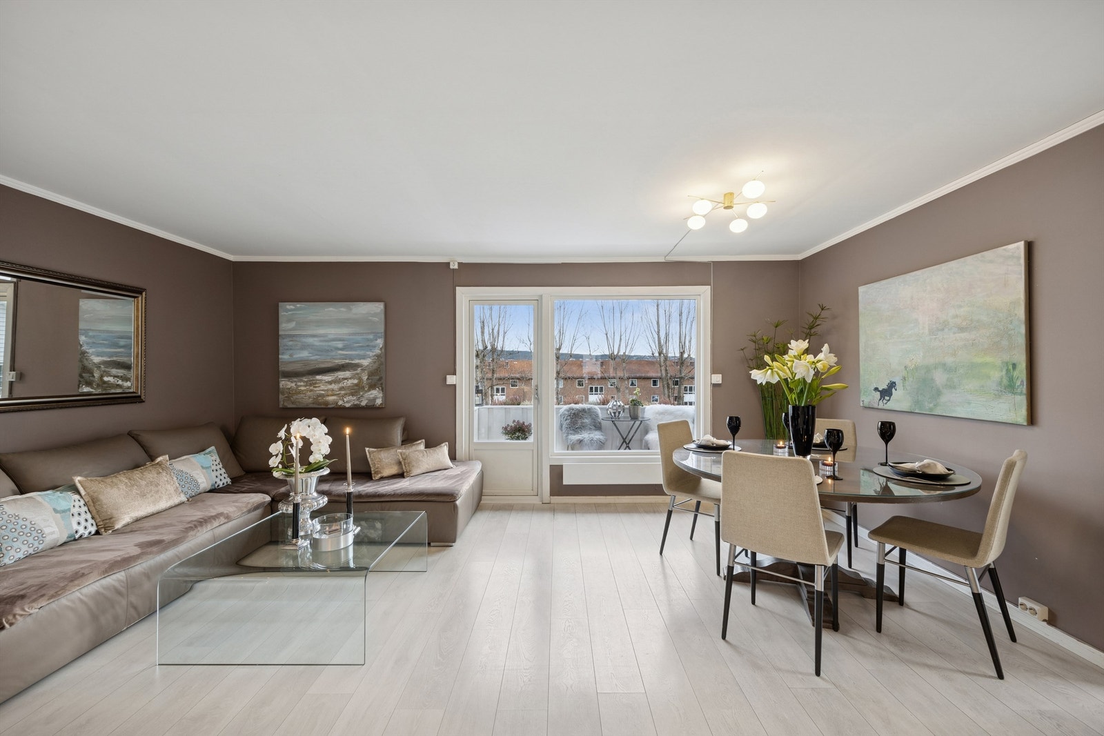 Stuen er romslig med utgang til balkongen og god plass til både sofa og spisebord Galleribilde