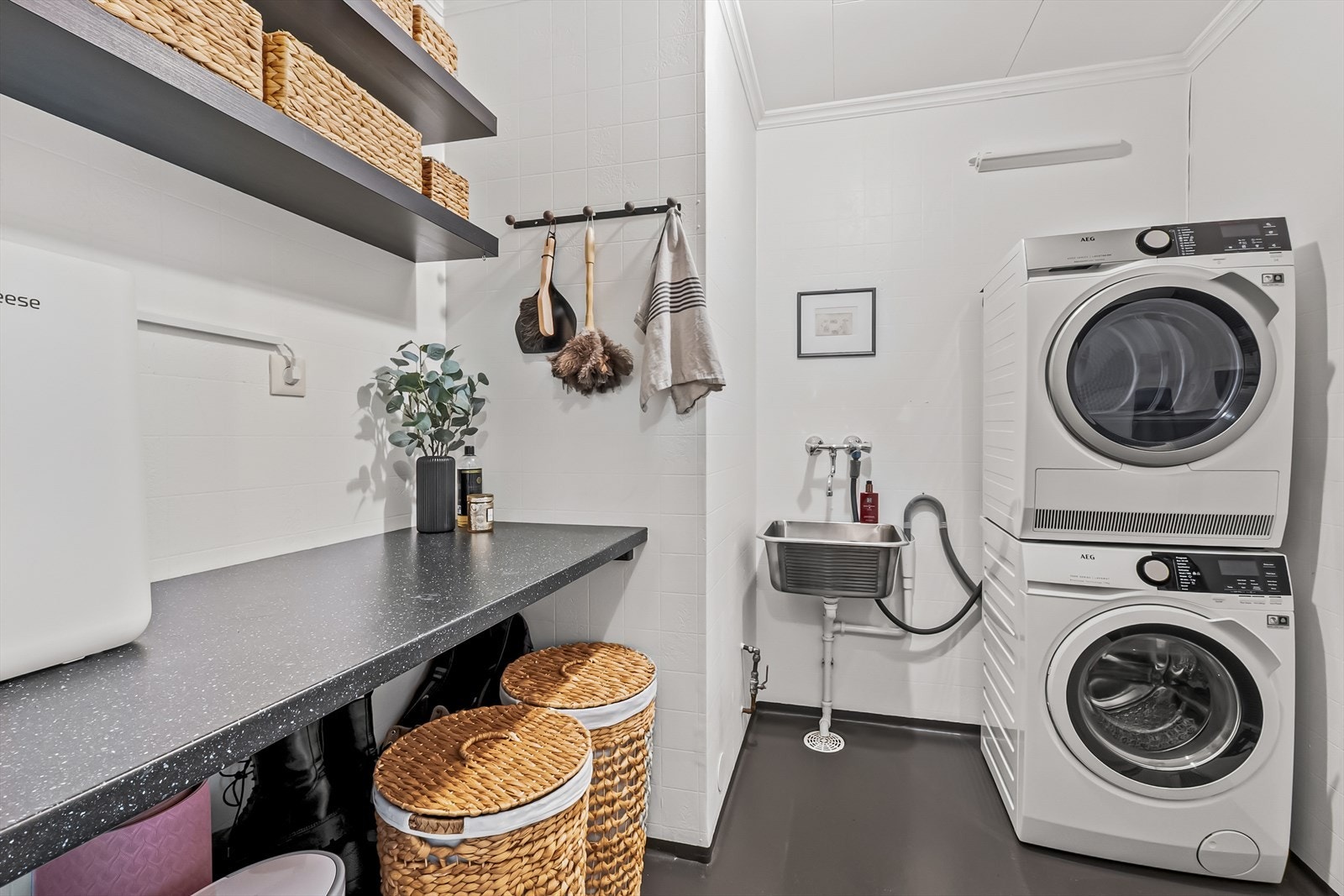 Praktisk utformet vaskerom med utslagsvask, plass til både vaskemaskin og tørketrommel, samt god arbeidsbenk. Galleribilde