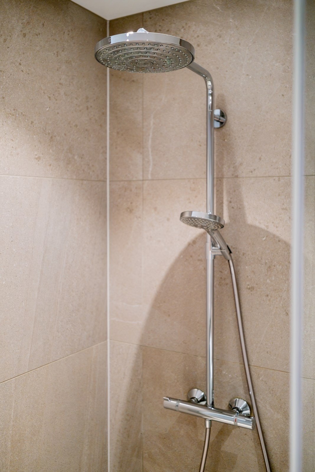 Badet er innredet med nedfelt servant over skuffeinnredning, speil, vegghengt toalett fra Duravit, og dusjhjørne med innfellbare glassvegger og regn- og hånddusj. Galleribilde