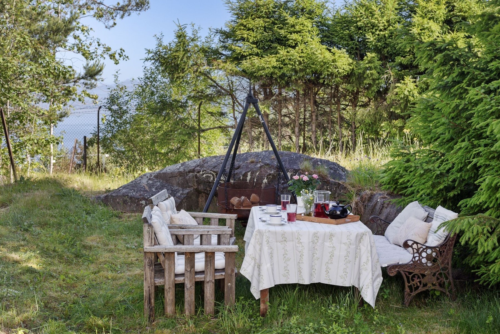 Stemningsfull del av hagen med bålpanne og naturskjønne omgivelser. Galleribilde