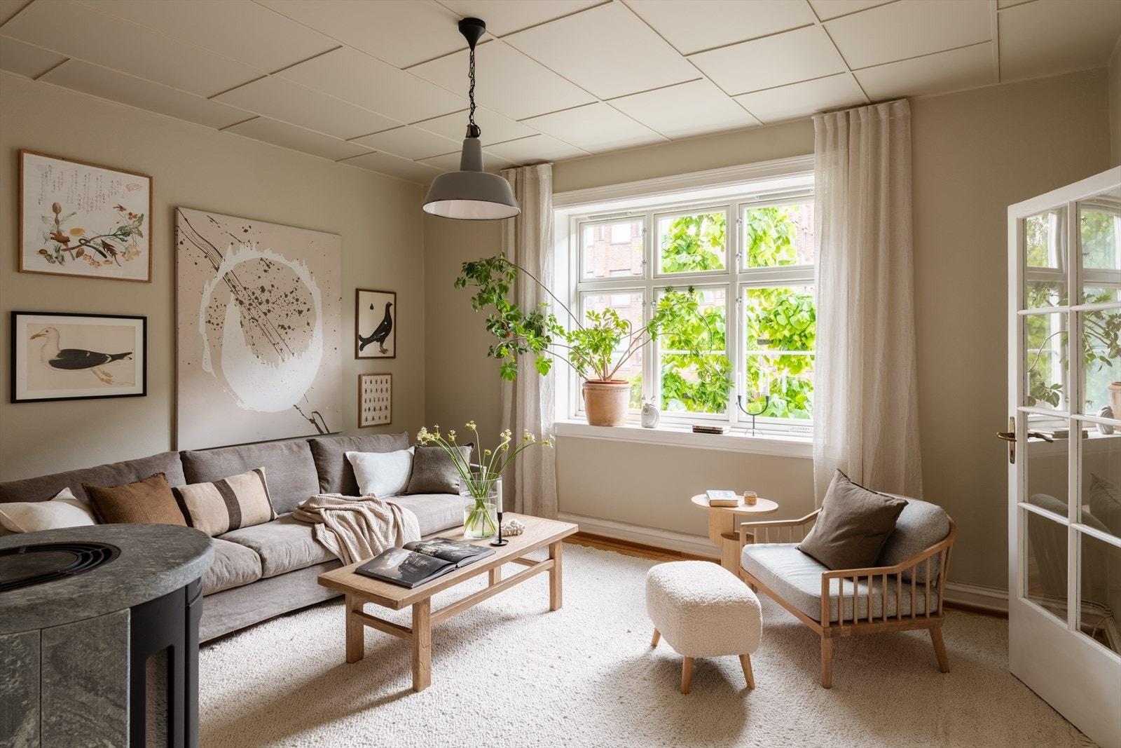 Stuen har en moderne peisovn og ligger i et av Oslos mest karakterfulle boligområder, Lindern Hageby. Galleribilde