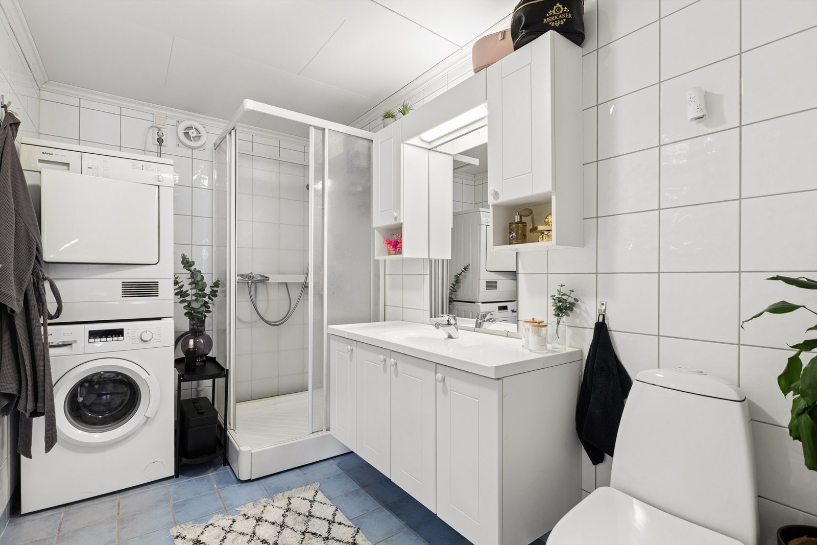 Badet i leiligheten har fliser på gulv og vegger, elektriske varmekabler og opplegg for vaskemaskin. Galleribilde