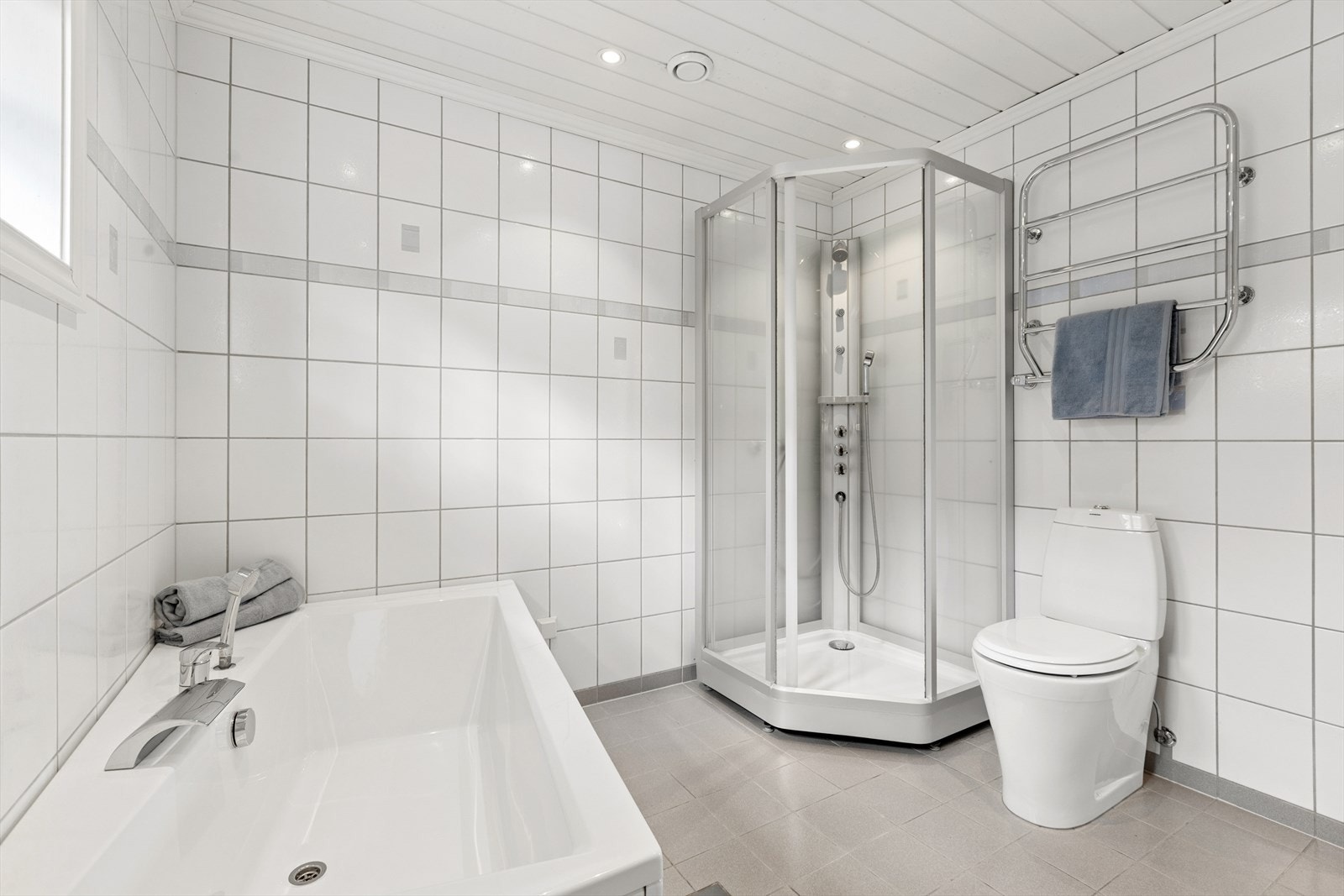Videre er badet utstyrt med et gulvstående toalett, dusjkabinett og badekar. Galleribilde