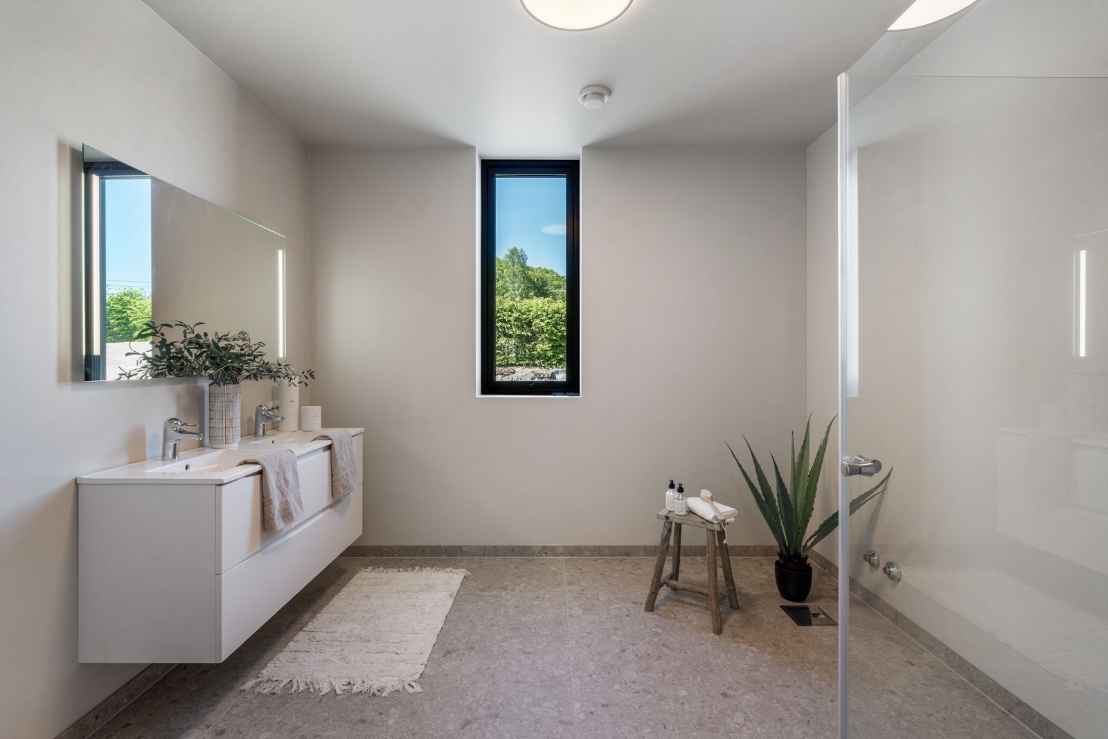 Badet har dusjløsning og til høyre i bildet er det opplegg for badekar. Basert på om badekaret ønsker i retning langs vegg under vindu eller langs vegg ved dusjen, er det også mulighet for høyskap om ønskelig.
Gulv og dusj er belagt med Pro Flodsten Earth Galleribilde