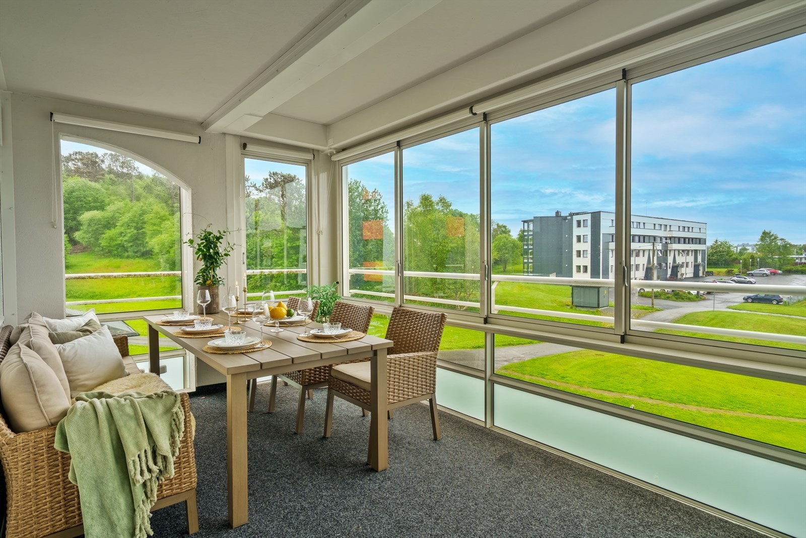 Vinduer fra gulv til tak som gir en luftig og fin romfølelse, med utsikt ut over borettslagets fellesarealer og fri natur Galleribilde