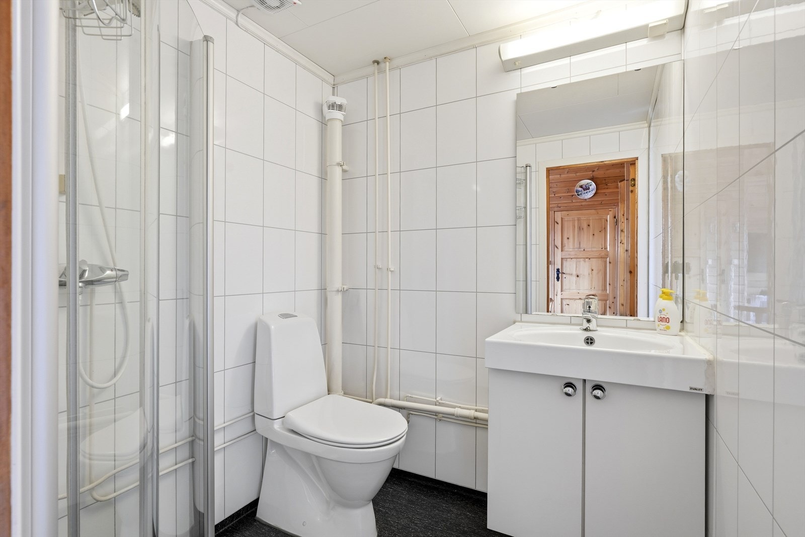 Badet er utstyrt med dusjhjørne, klosett, servantinnredning og gulvvarme. Galleribilde