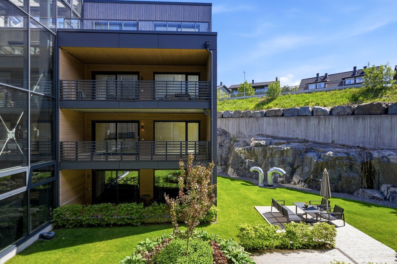 Moderne arkitektur med en kombinasjon av trepanel og mørke fasadeplater. Galleribilde