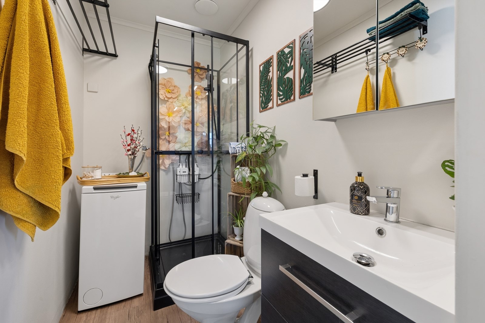 Bad med dusj, servant med oppbevaring, toalett og plass til vaskemaskin. Galleribilde