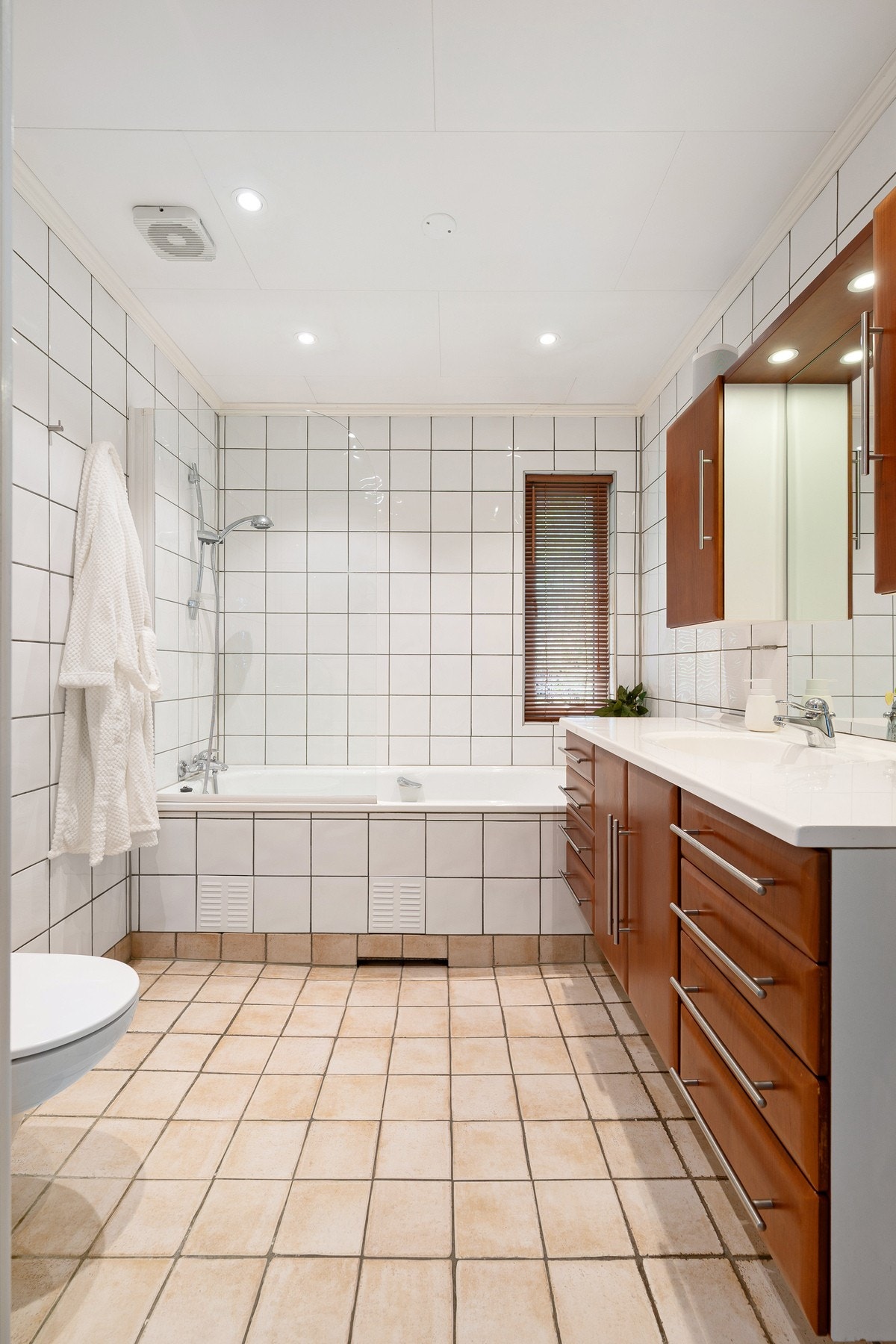 Flislagt, romslig bad med gulvvarme og god belysning med downlights Galleribilde
