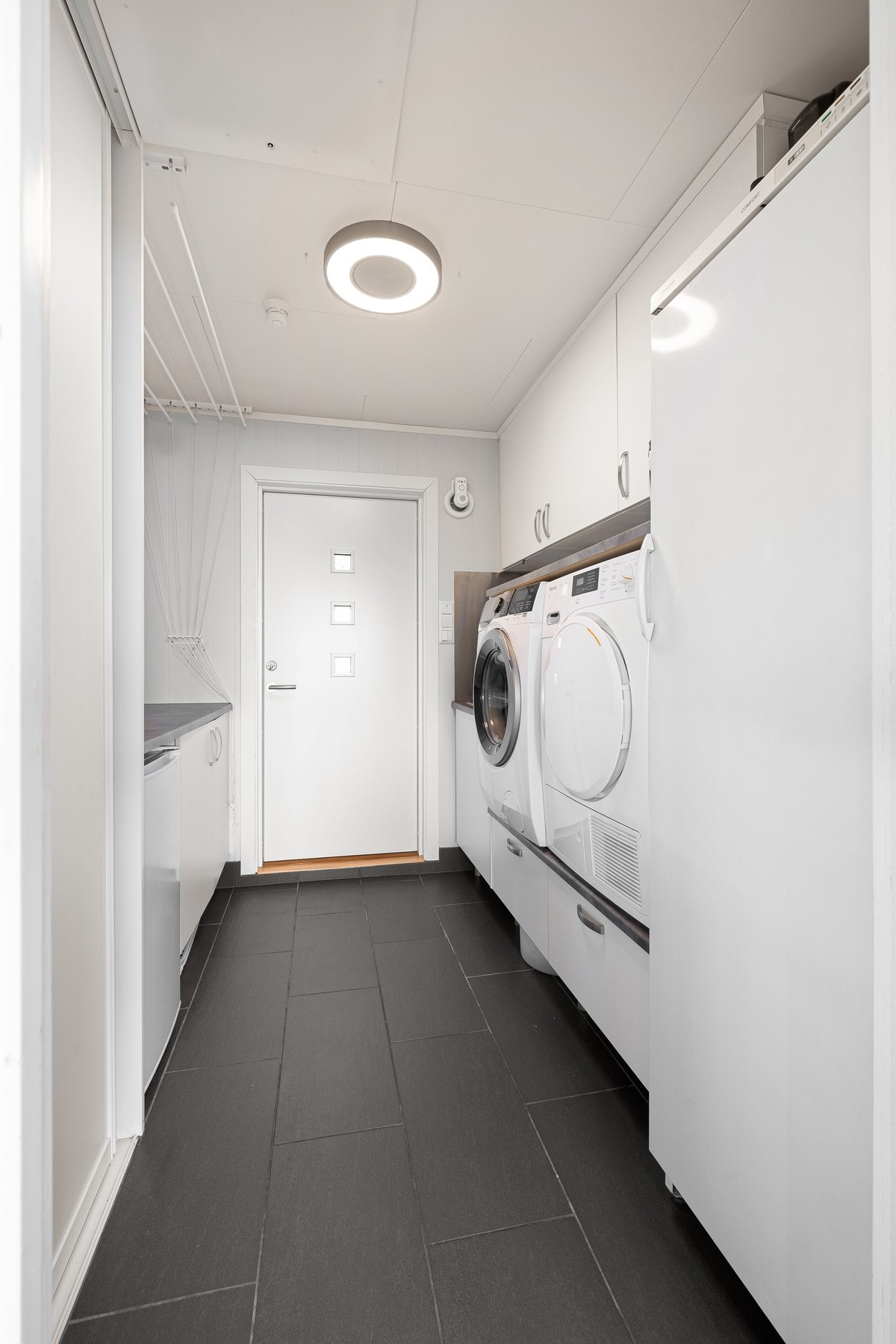 Eget vaskerom er alltid kjekt! Stort og godt med innredning på begge sider, varme i gulvet og egen inngang fra baksiden av huset Galleribilde