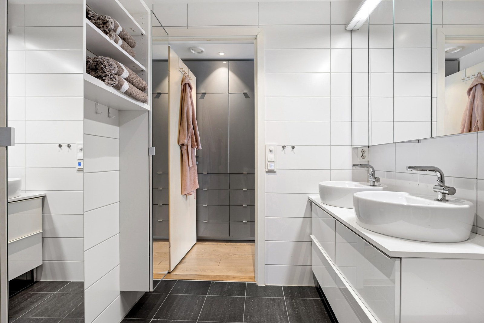 Badet er utstyrt med vegghengt WC, dusjhjørne med innfellbare dører, dobbelt høyskap samt opplegg for vaskemaskin. Galleribilde