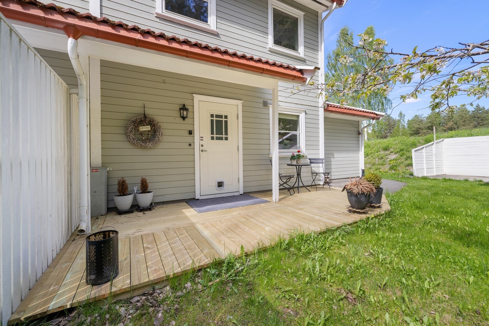 Overbygget inngangsparti med en hyggelig terrasseplatting. Galleribilde