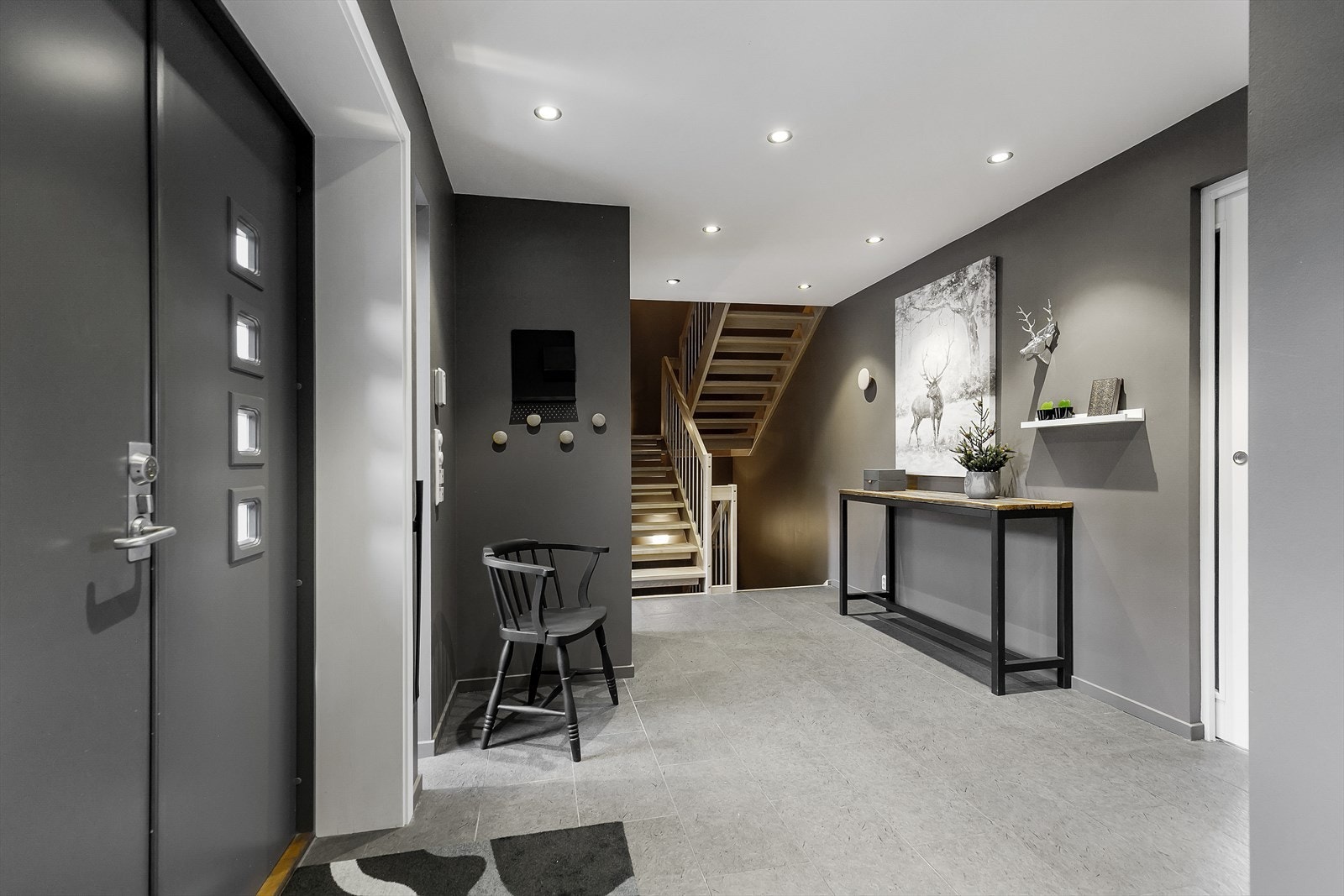 Inn kommer man til en romslig hall med downlights i tak og flis på gulv Galleribilde