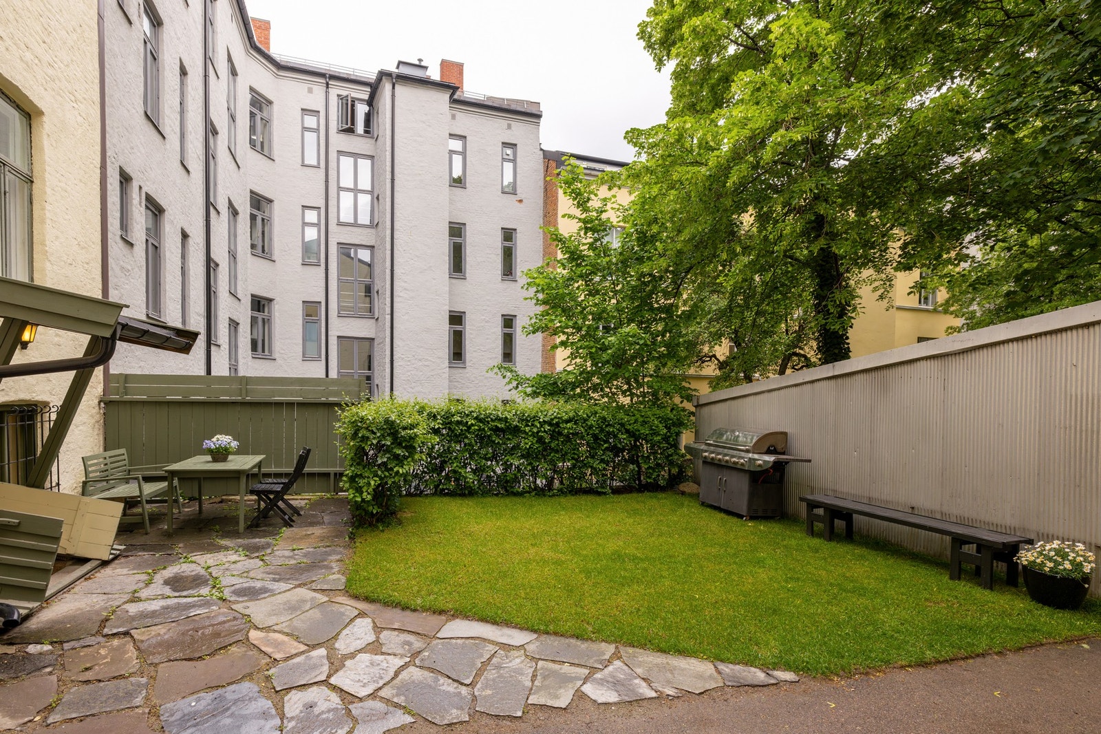Bakhage med sittegruppe, sykkelparkering og gressplen. Galleribilde