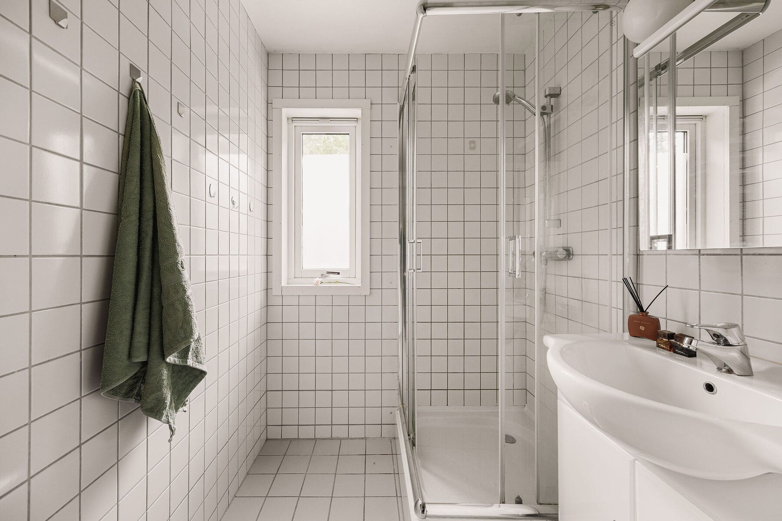 Badet er innredet med vegghengt servantinnredning med tilhørende speilskap, dusjkar med dører og opplegg for vaskemaskin. Galleribilde