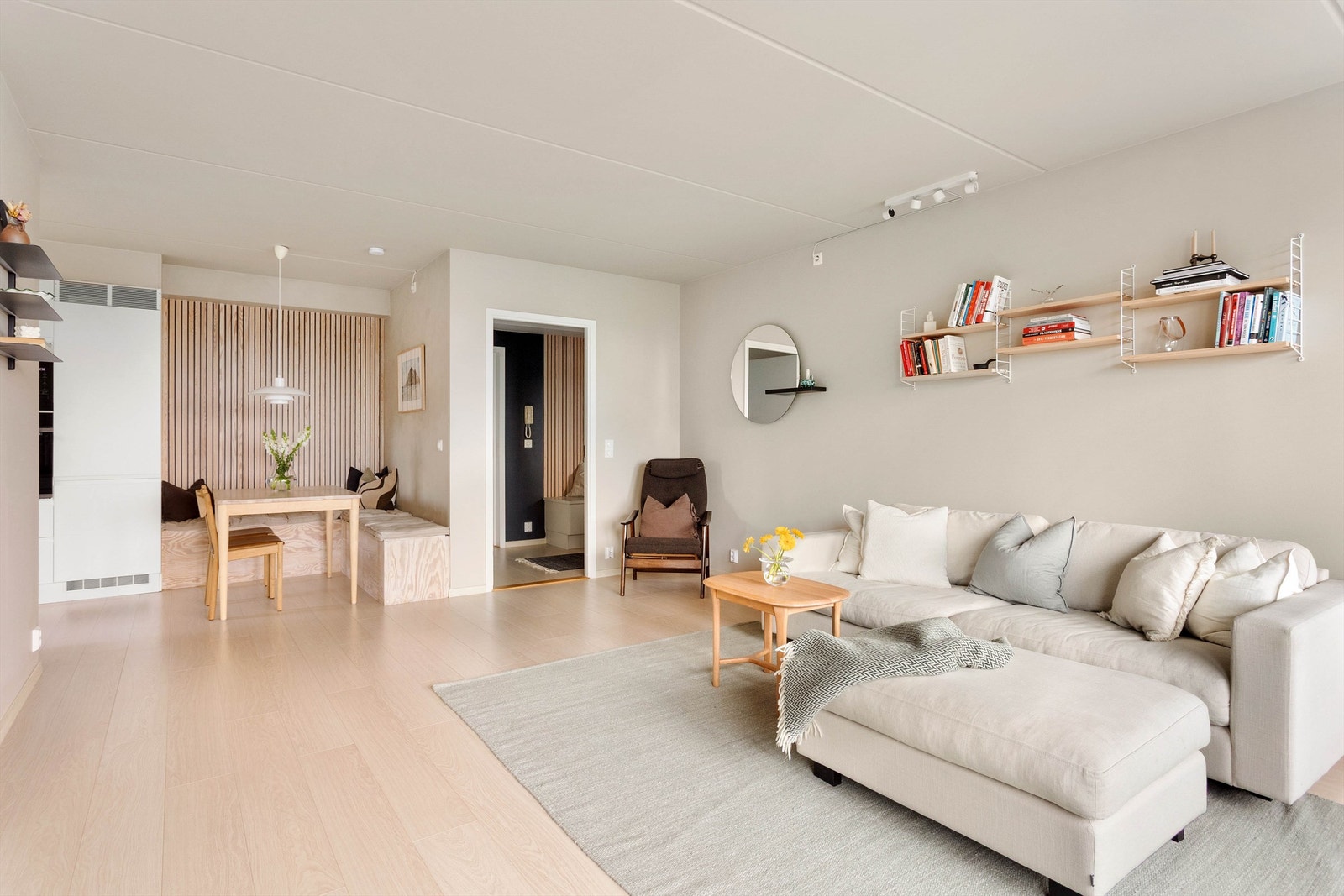 Den romslige stuen har god plass til både sofagruppe og spisebord, og fremstår som boligens naturlige samlingspunkt. Galleribilde