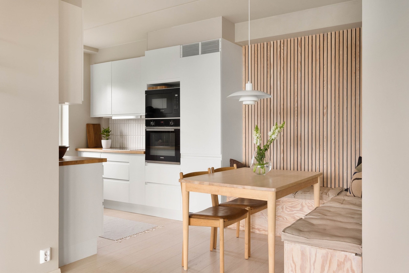 Spiseplassen er smart plassert i tilknytning til kjøkkenet, med en dekorativ spilevegg som skaper en lun og innbydende atmosfære. Galleribilde