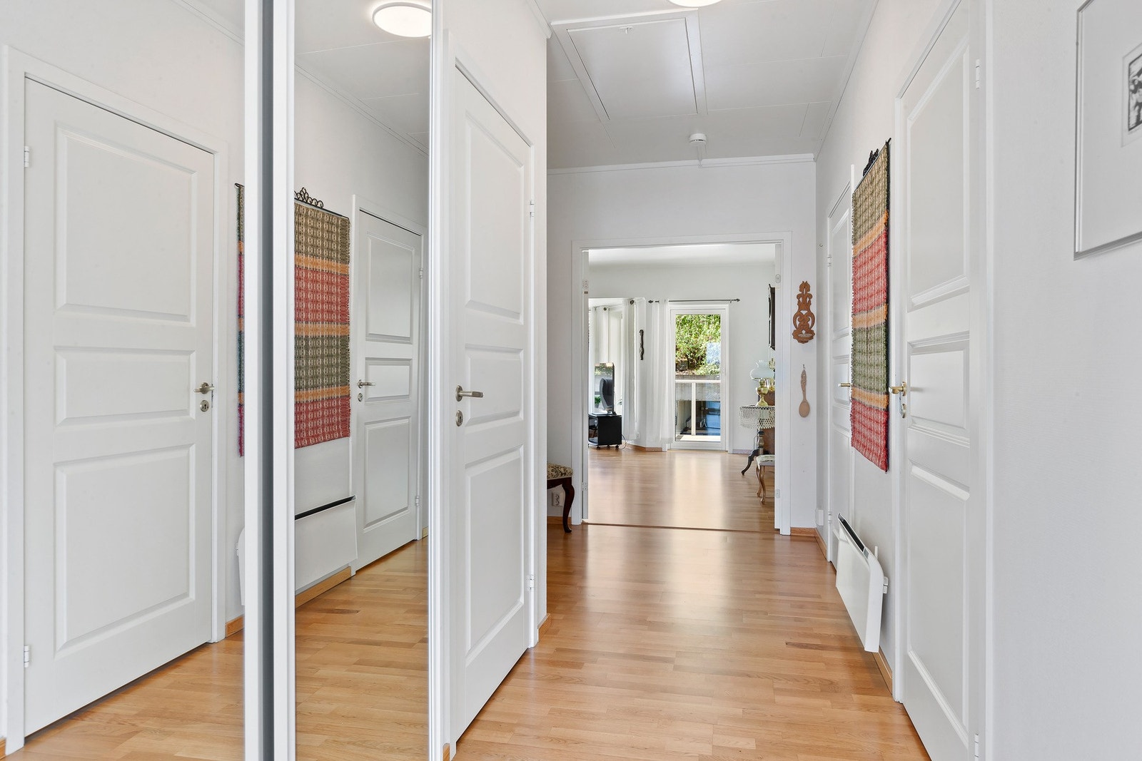 Velkommen inn! Praktisk gang med god plass til å henge fra seg i romslig skyvedørsgarderobe. Galleribilde