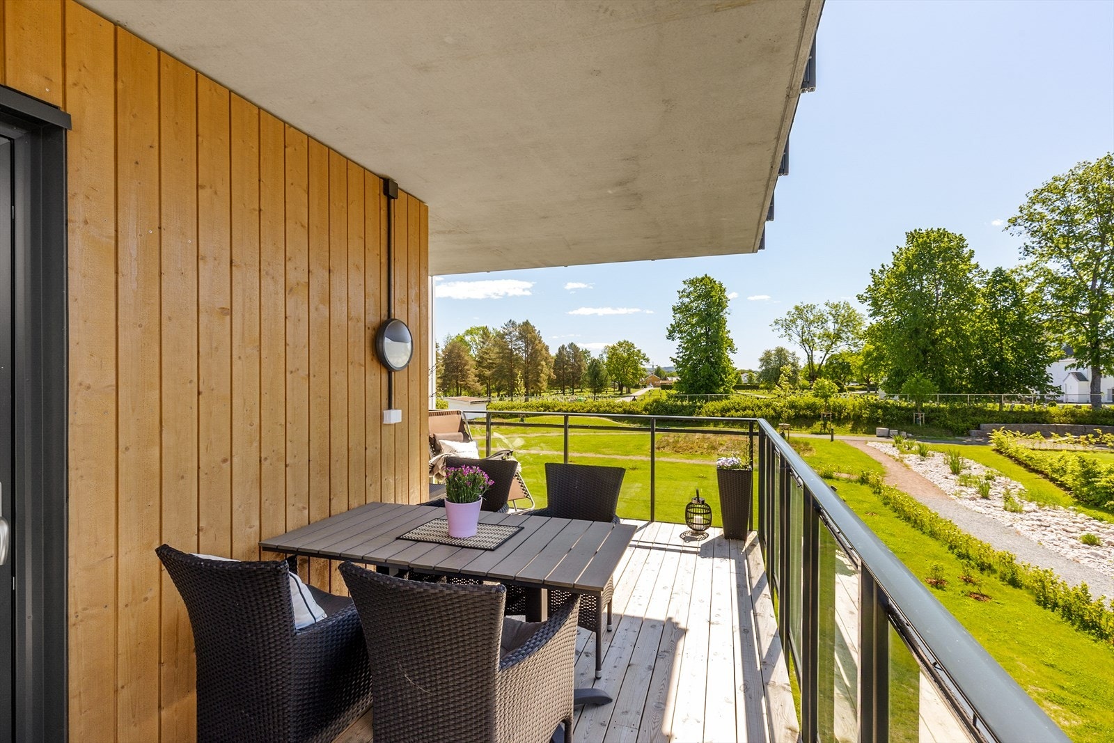 Balkongen har terrassebord og rekkverk med glass, som gir en uhindret utsikt over fellesområdene. Galleribilde