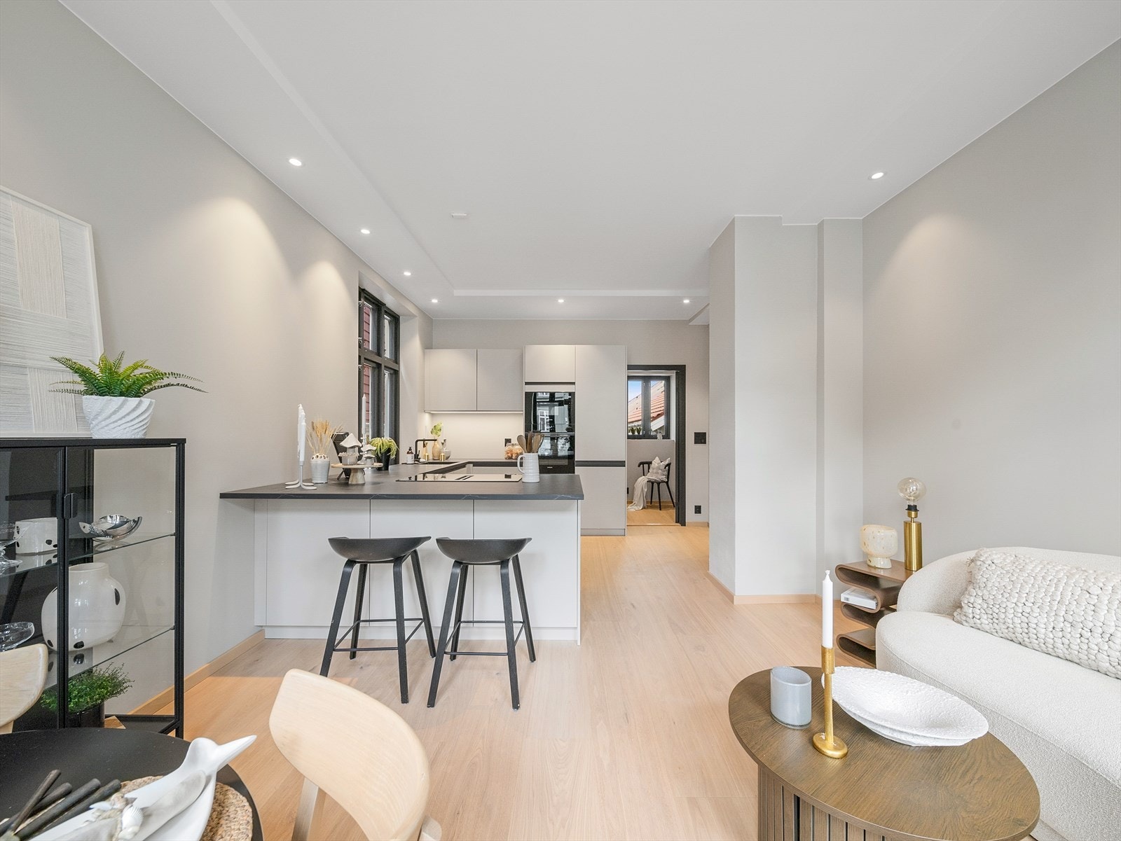 Rommet er smart disponert med naturlige soner for både sofagruppe, spiseplass og kjøkken, samtidig som den åpne løsningen gir en luftig og sosial atmosfære. Galleribilde