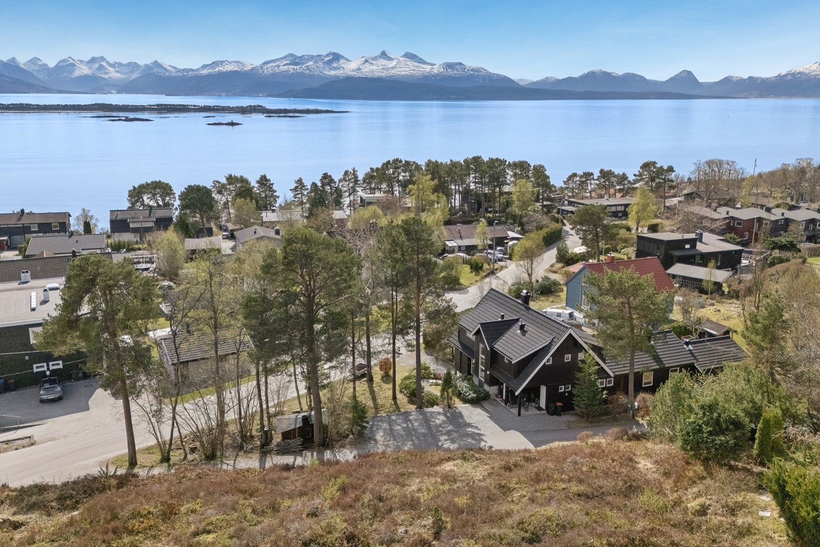Fra tomten er det en vidstrakt og åpen utsikt over fjorden og de omkringliggende fjellene. Galleribilde