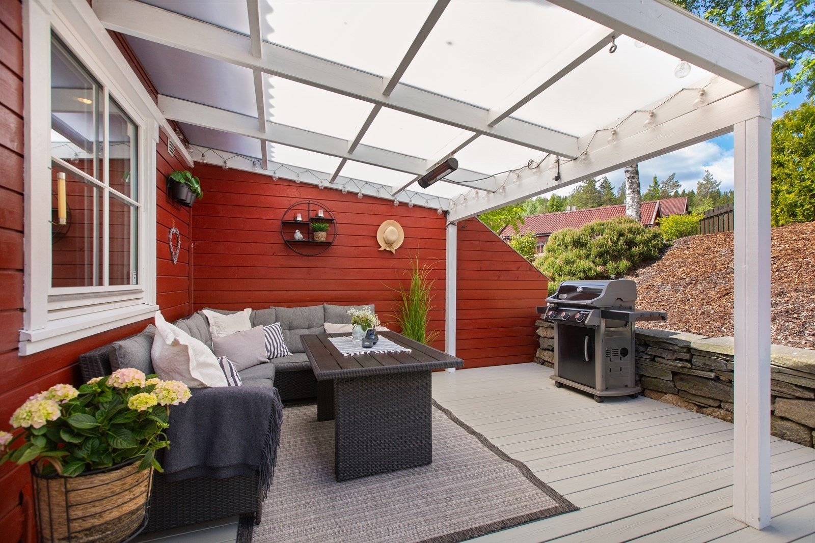 Den delvis overbygde terrassen på baksiden fungerer som en forlengelse av oppholdsrommene inne, og kombinerer både ly og åpen himmel på en gjennomført måte. Perfekt for hyggelig måltider. Galleribilde