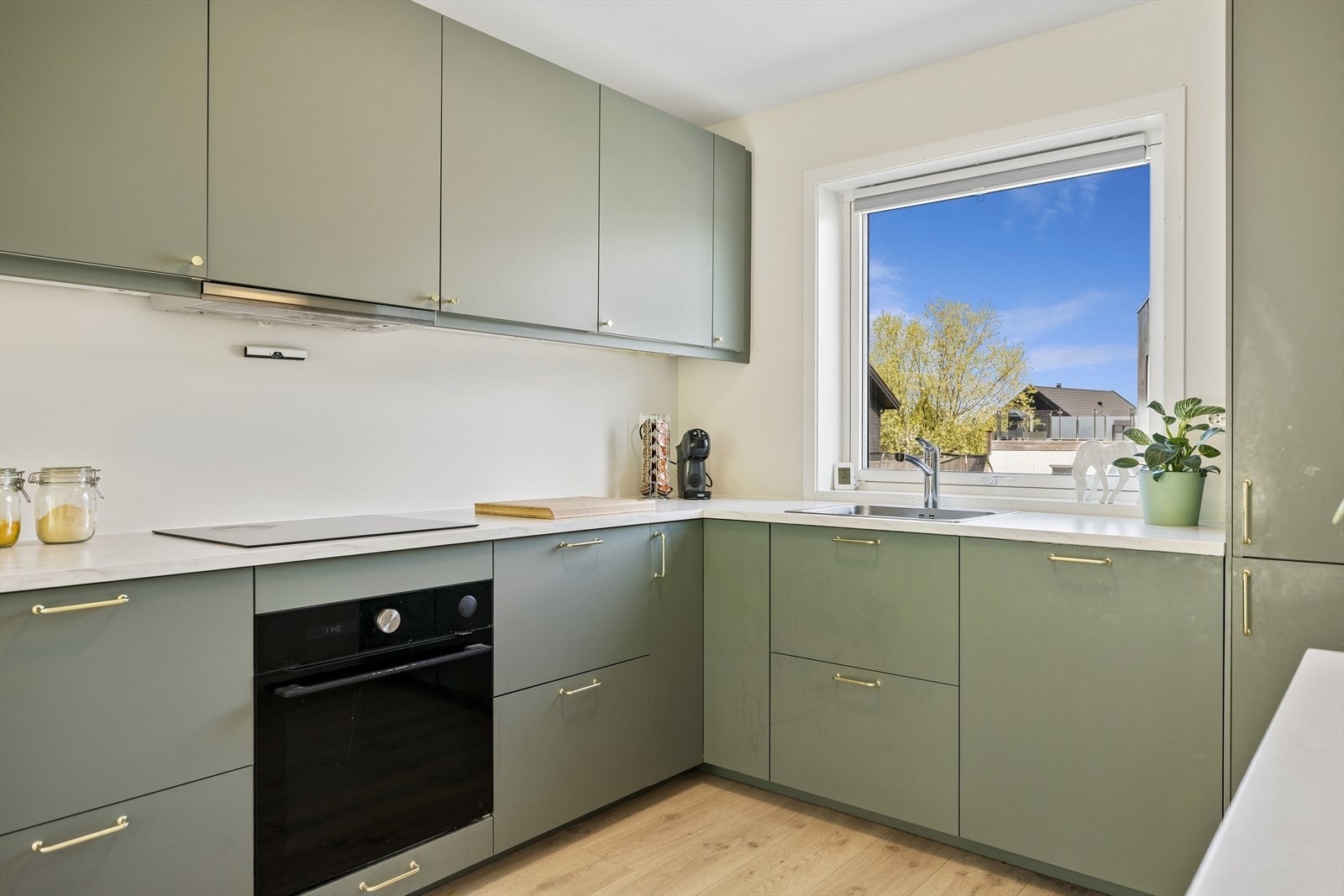 Takhøy kjøkkeninnredning med glatte fronter og en slitesterk, laminert benkeplate. Galleribilde