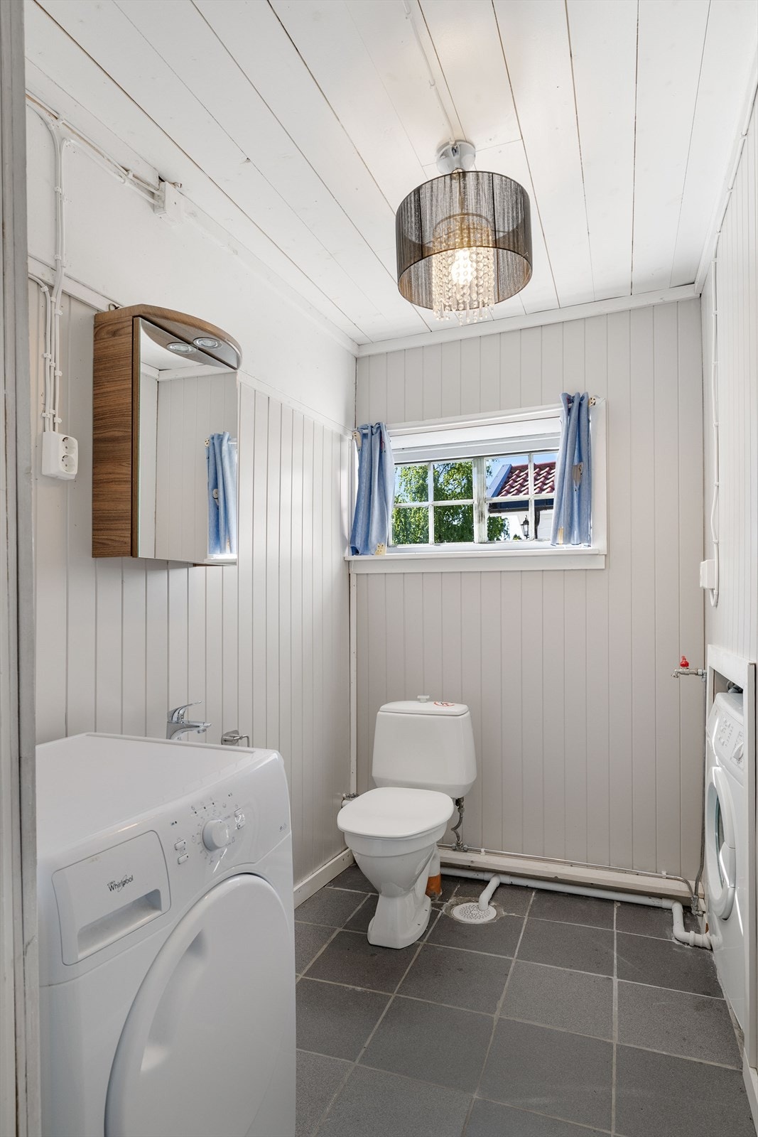 Toalettrom i tilknytning til garasjen, innredet med toalett, servant og opplegg for vaskemaskin. Galleribilde