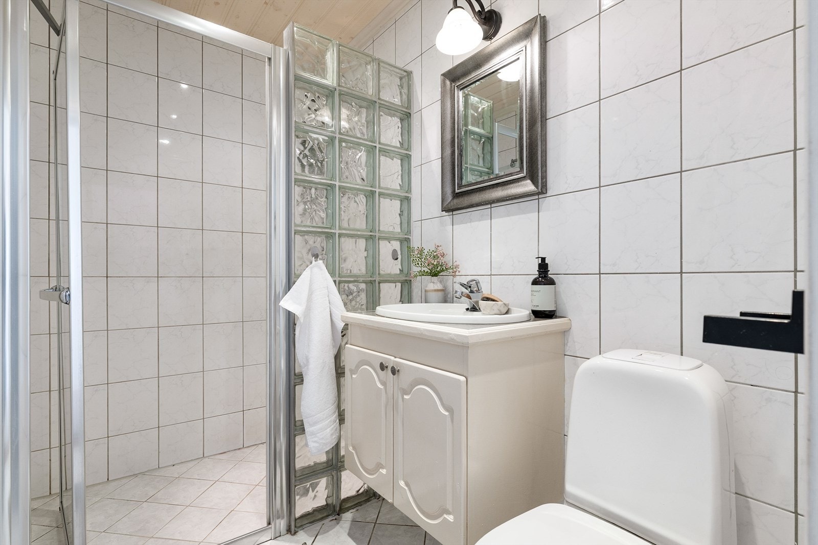 Badet i hovedetasjen er utstyrt med flislagt gulv med elektriske varmekabler, dusjhjørne og servantinnredning. Galleribilde