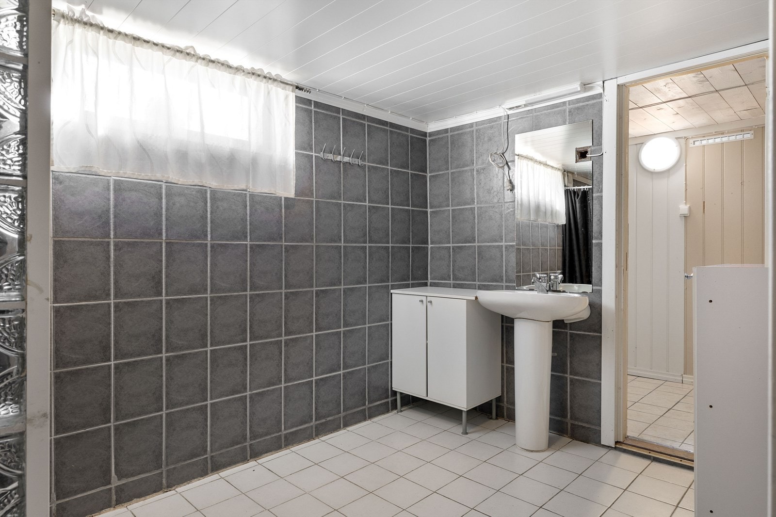Badet i kjelleren har flislagt gulv med varmekabler og servant. Galleribilde