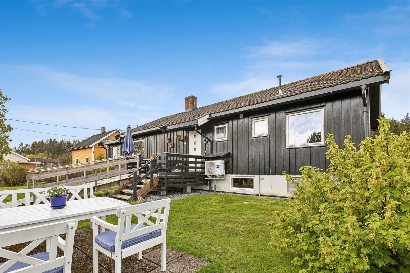 Fasade og uteplass inngangsside med en koselig hellebelagt uteplass. Galleribilde