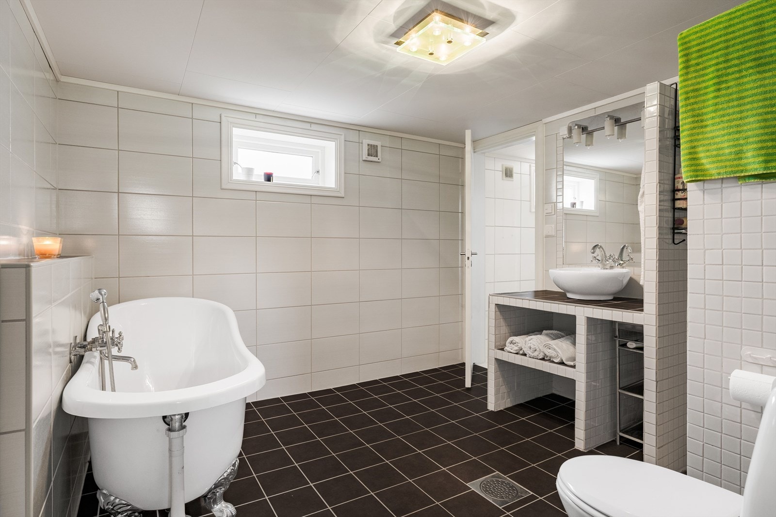 Badet i underetasjen er oppgradert i 2012 og innredet med dusjhjørne, toalett, badekar og servant. På gulv og vegger er det fliser. Galleribilde