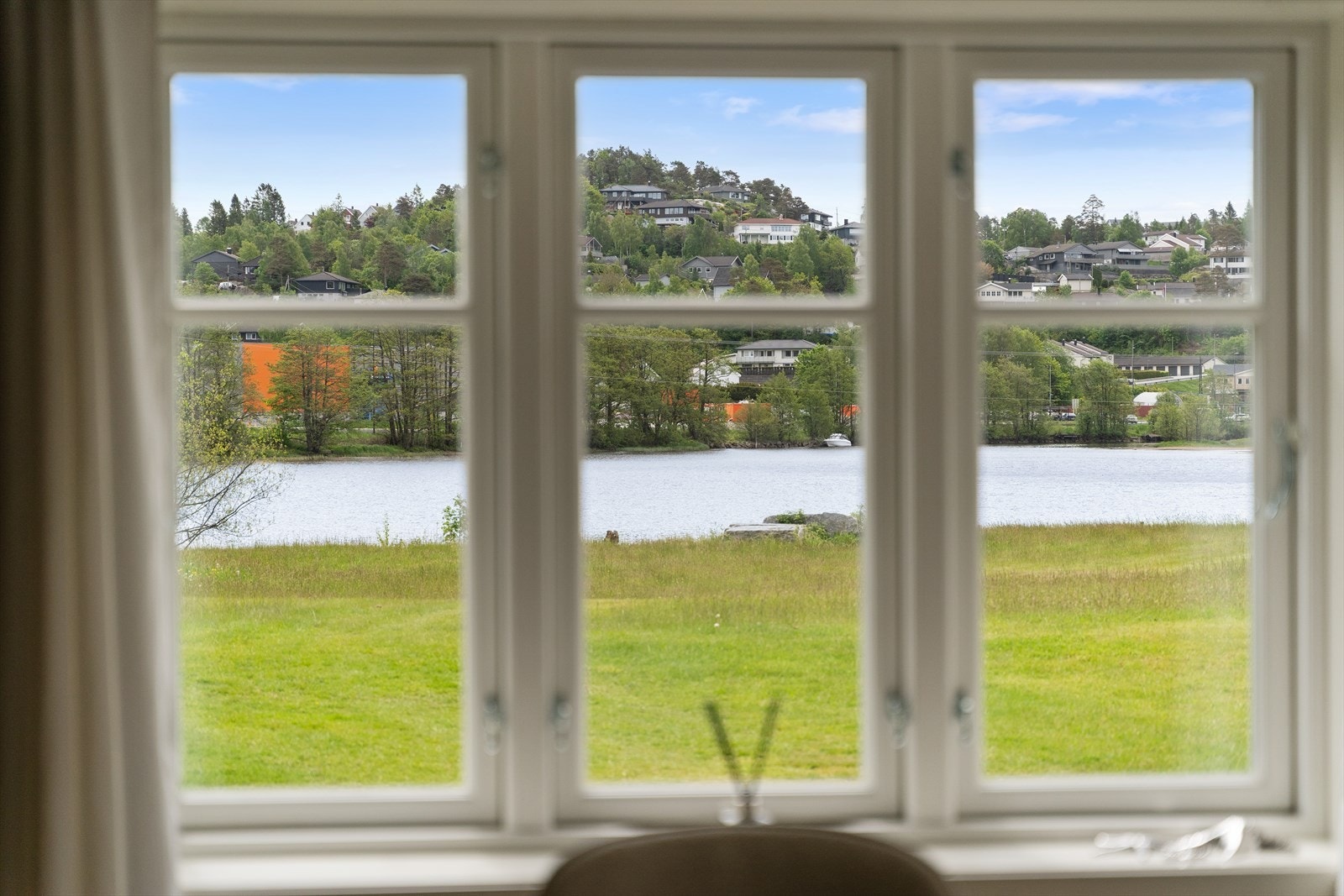 Fra boligen ser man ut over elva og det omkringliggende landskapet. Galleribilde
