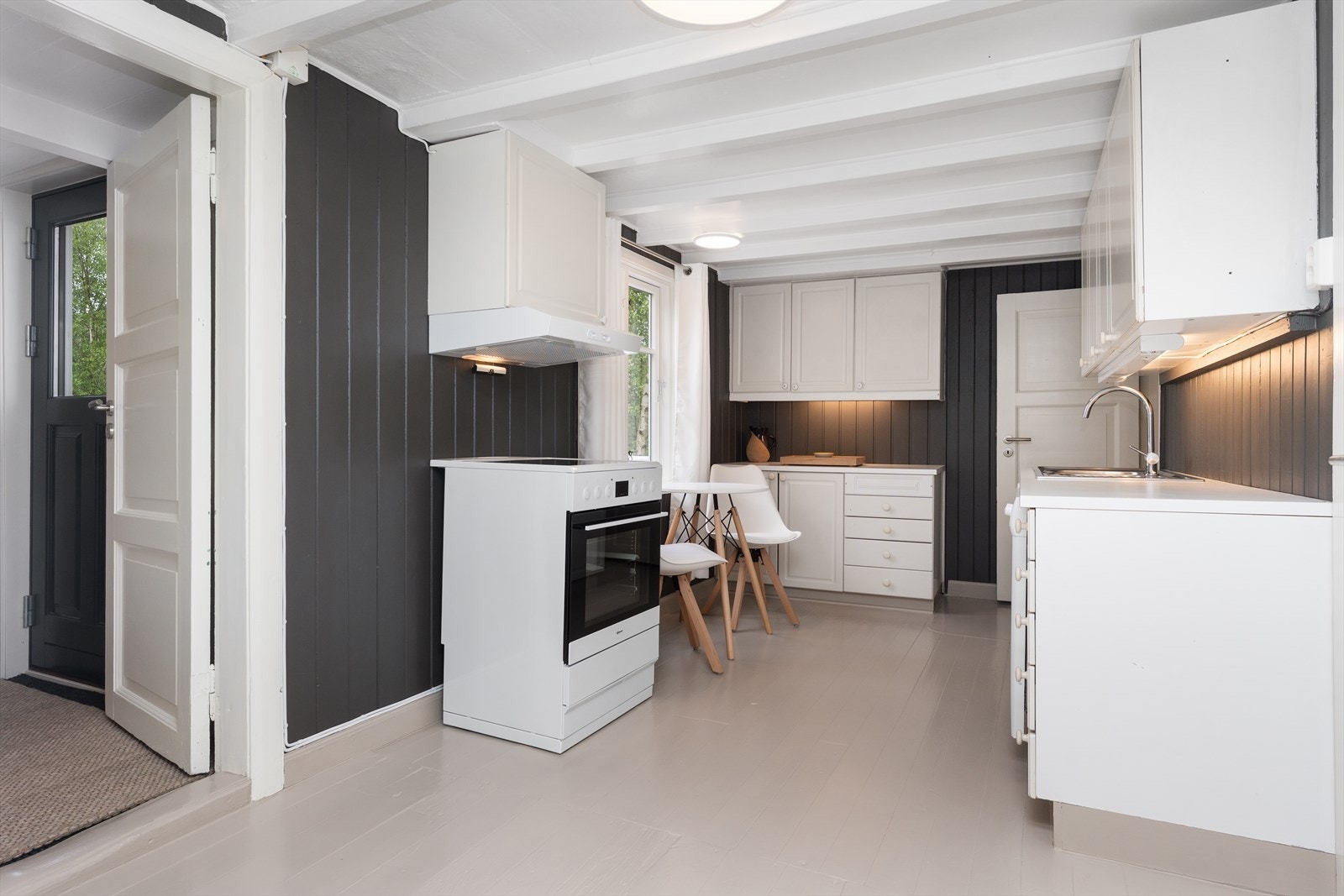 Kjøkken med profilert innredning, laminert benkeplate og opplegg for hvitevarer. Galleribilde
