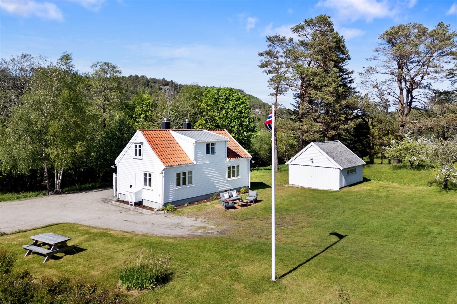 Eneboligen og garasjen ligger fint plassert på den store tomten. Galleribilde
