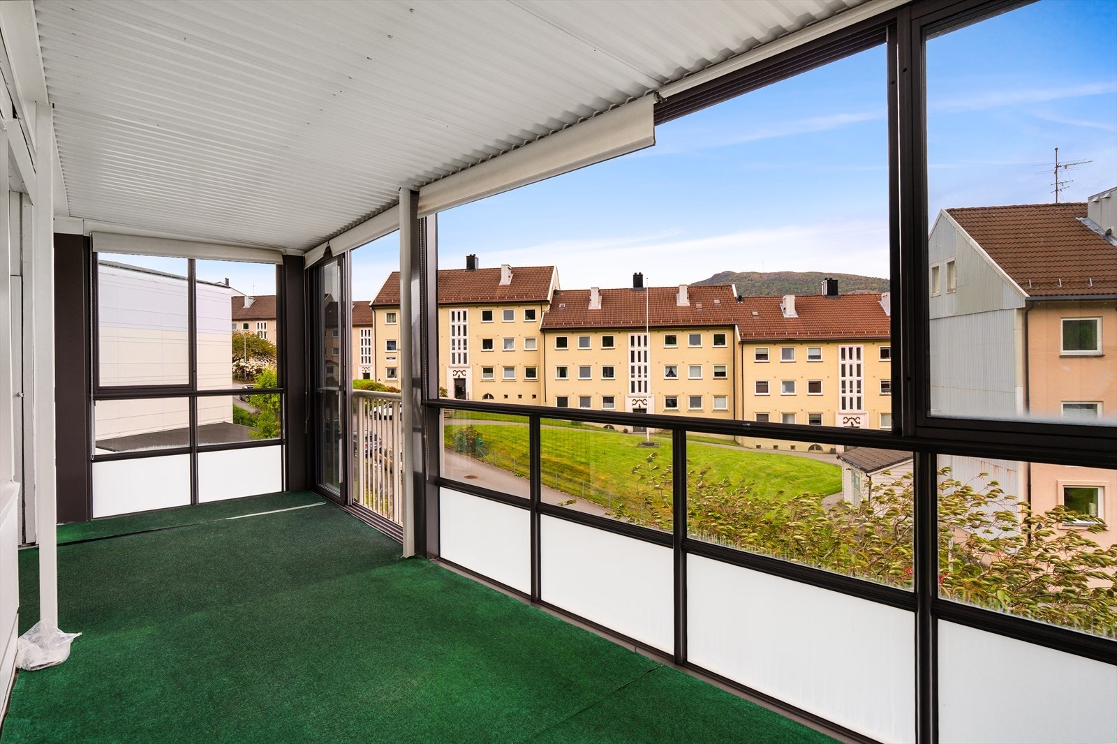 Fra stuen har man utgang til en stor innglasset balkong på 18m² - praktisk med skyvedører/vinduer som åpnes og lukkes etter behov. Galleribilde