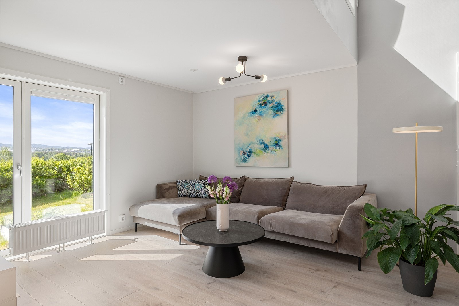 Stuen ble malt i 2024 i tidsriktige farger, og på gulvet er det lagt laminat av typen Eik Modern Grey. Galleribilde