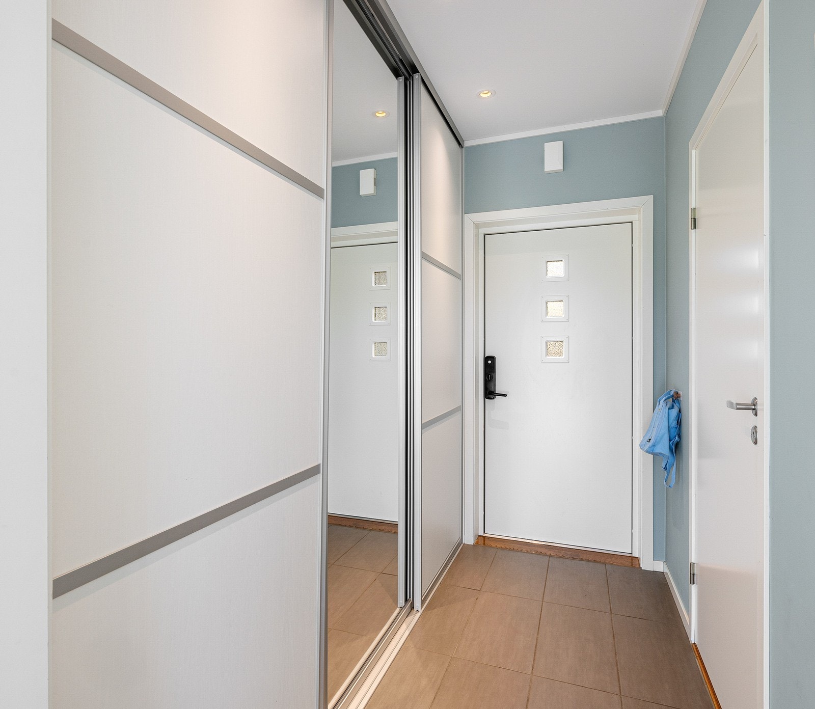 Inne i entréen er det rikelig med oppbevaringsplass i en stor skyvedørsgarderobe fra KVIK med integrerte skohyller. Galleribilde