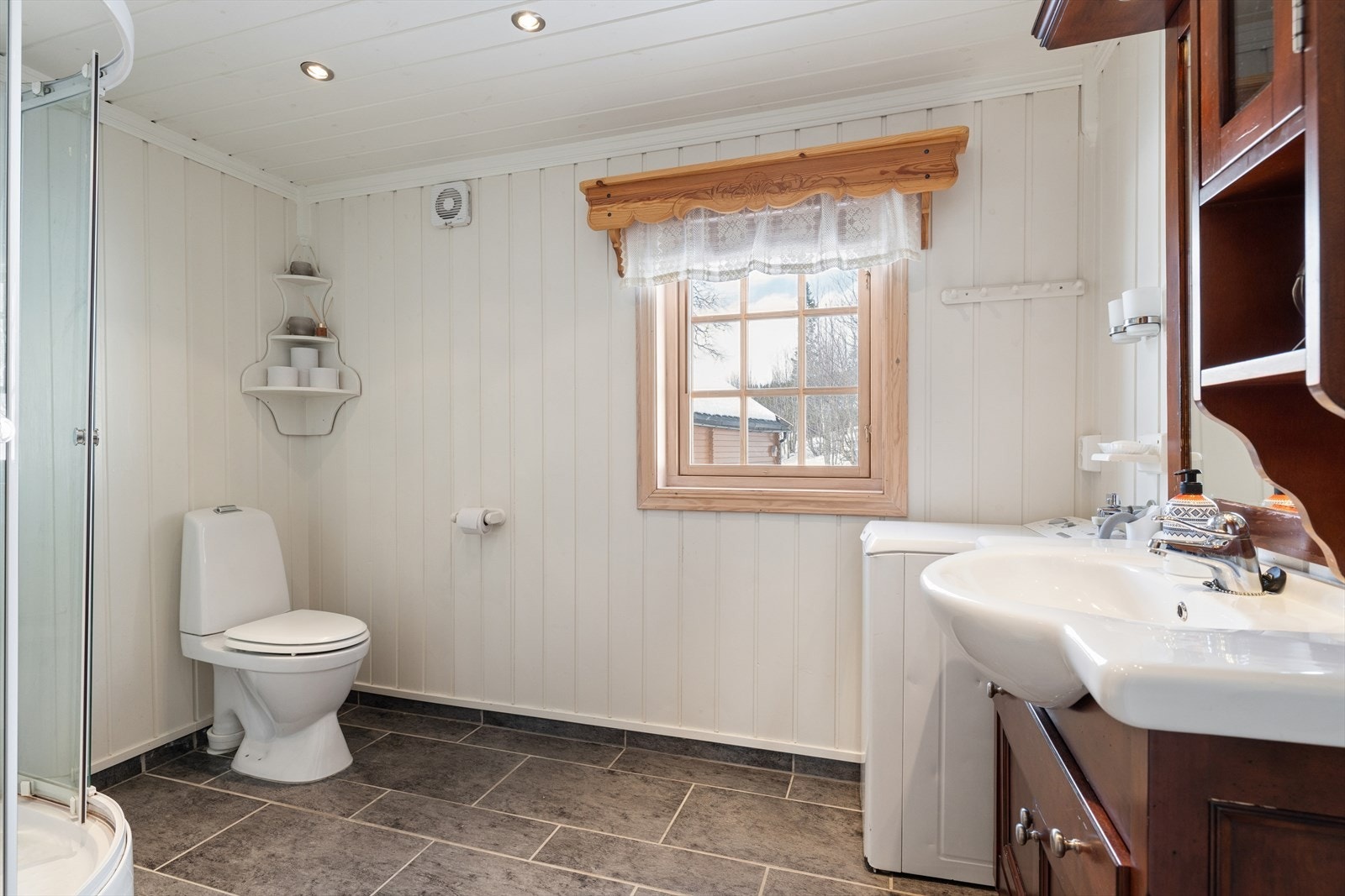 Badet har flislagt gulv med varmekabler, malt panel på veggene og downlights i taket. Galleribilde