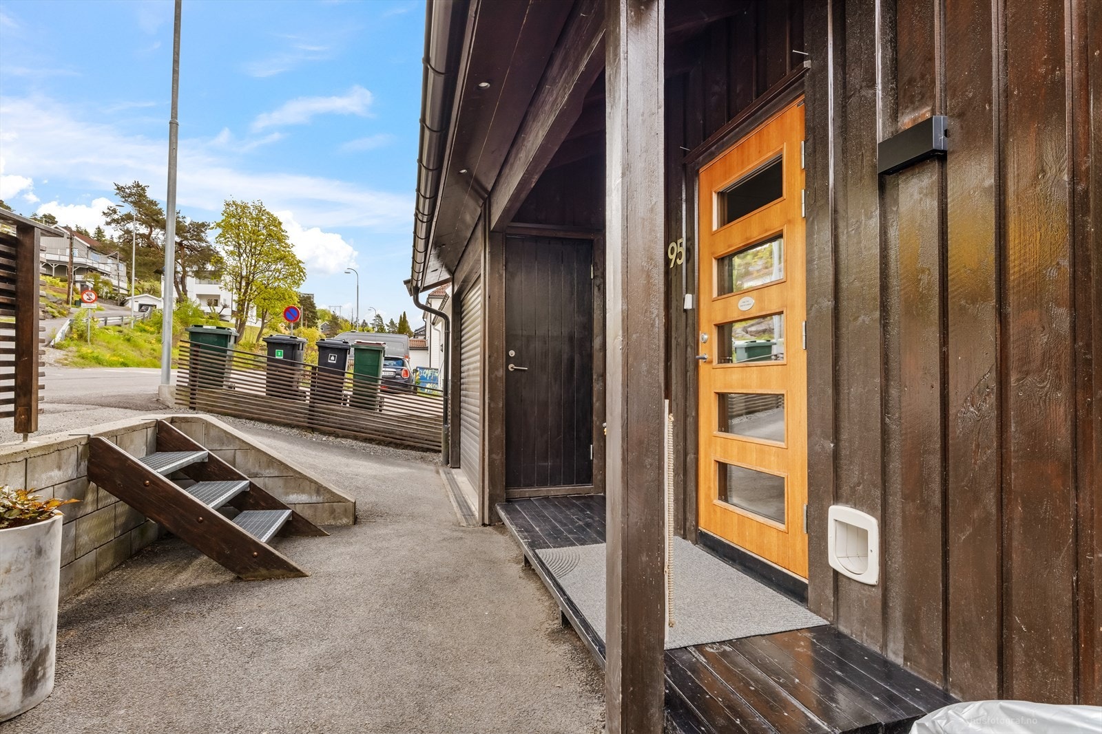 Overbygget inngangsparti med terrasseplatting og adkomst til garasje. Galleribilde