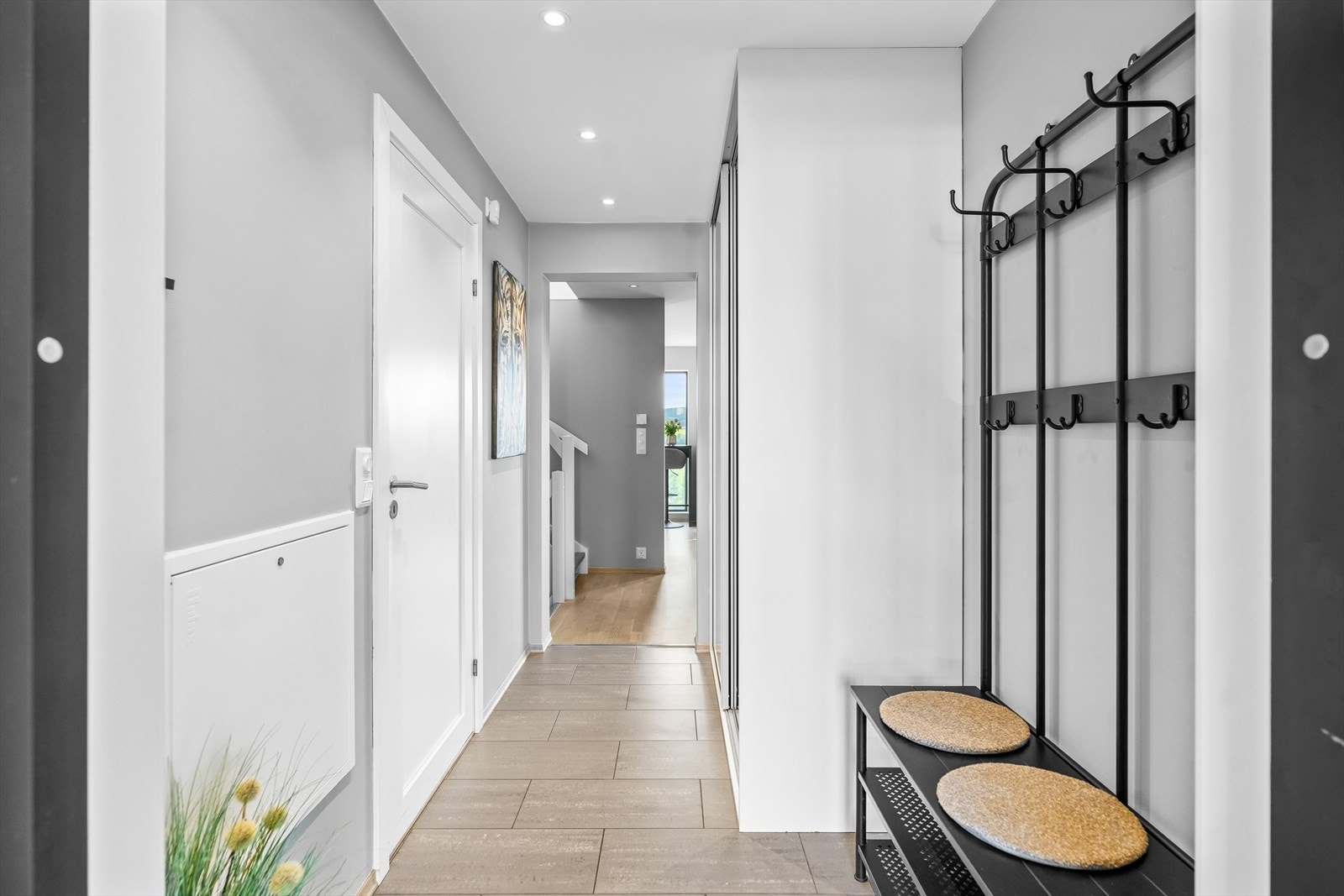 Vel inne i entréen er det god plass til å henge fra seg yttertøy og sette fra seg sko. Det er montert en svært romslig skyvedørsgarderobe med speilfronter. Galleribilde