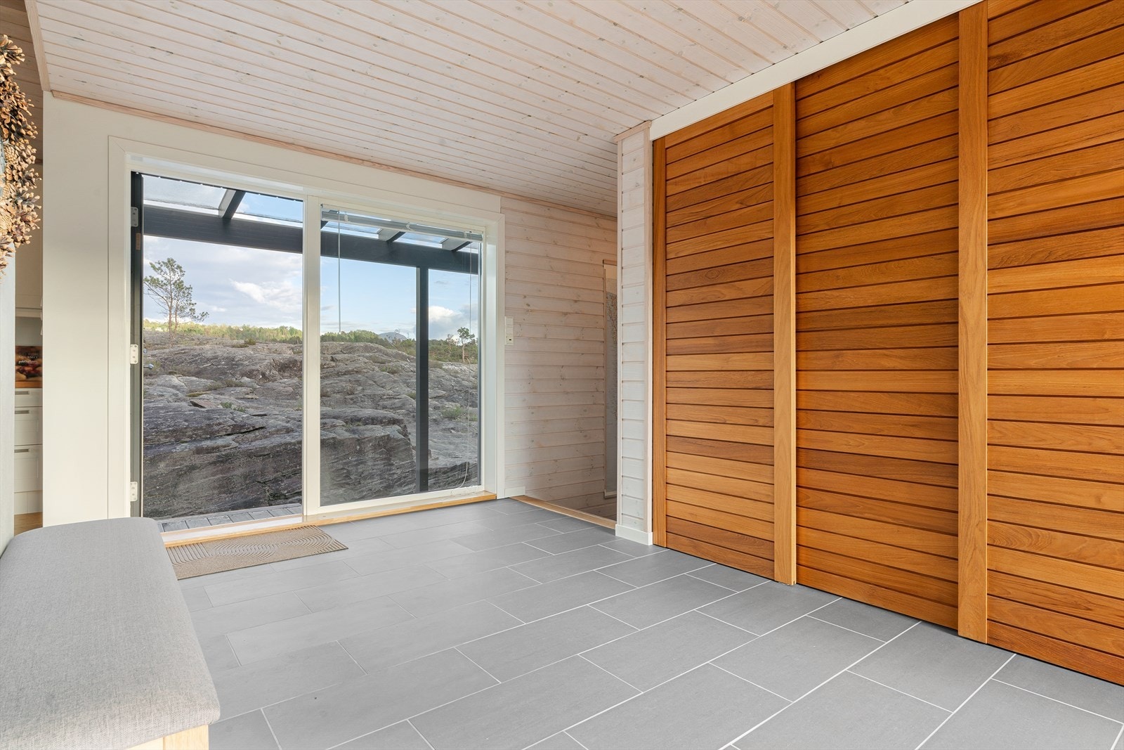 Hallen har flislagt gulv med gulvvarme. Garderobedører av heltre teak. Galleribilde