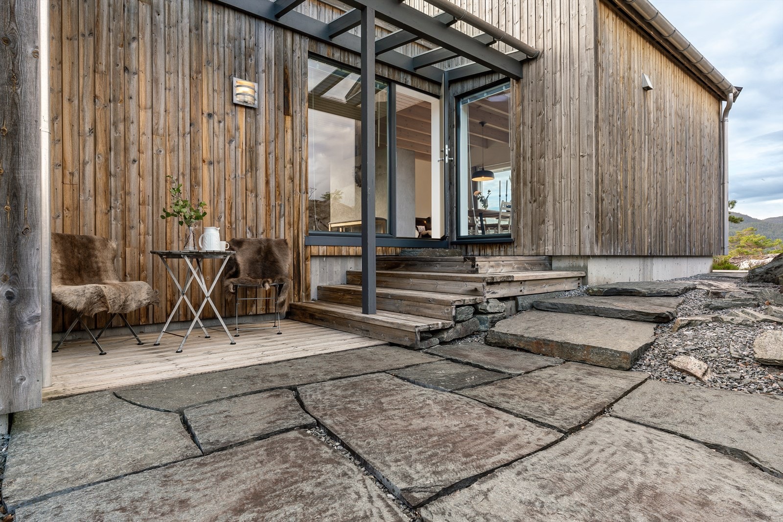 Terrasse for morgenkaffe på fine dager. Delvis overbygget inngangsparti. Galleribilde